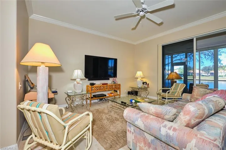 Living area with a ceiling fan and crown molding