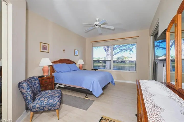 Bedroom featuring access to exterior, ceiling fan, a water view, and light wood finished floors