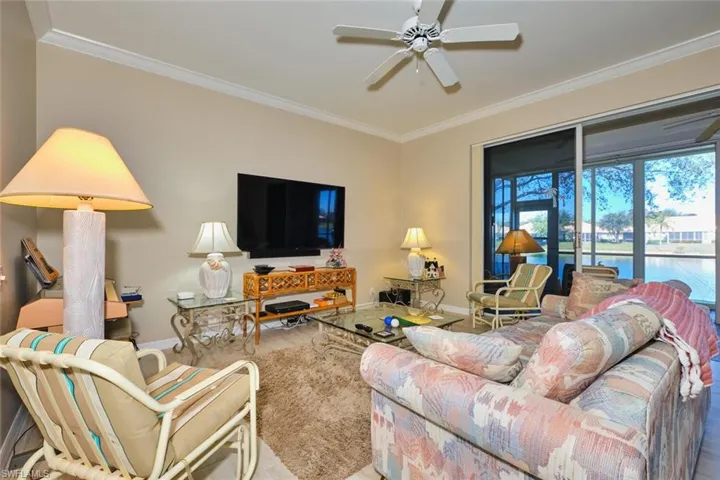 Living area with ceiling fan and ornamental molding