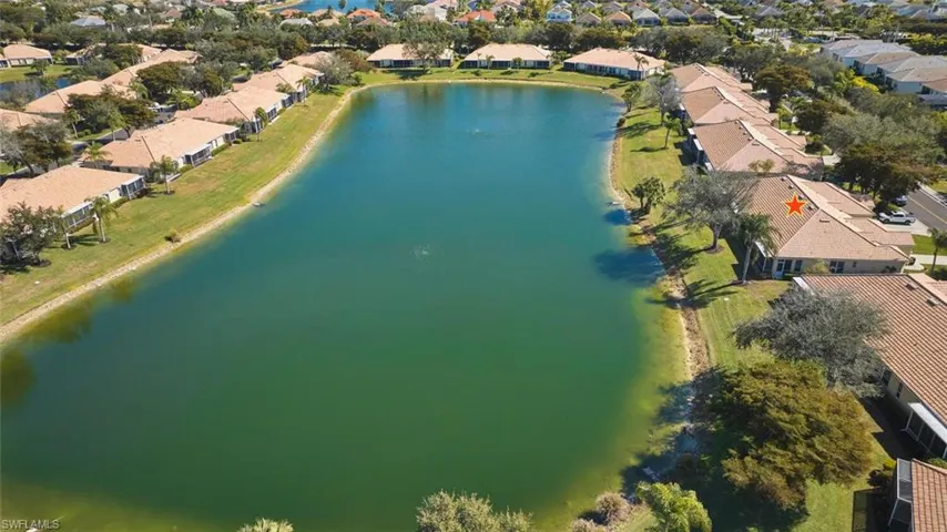 Aerial view of property and surrounding area with nearby suburban area and a large body of water