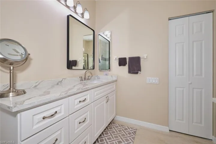Full bathroom featuring vanity and a closet