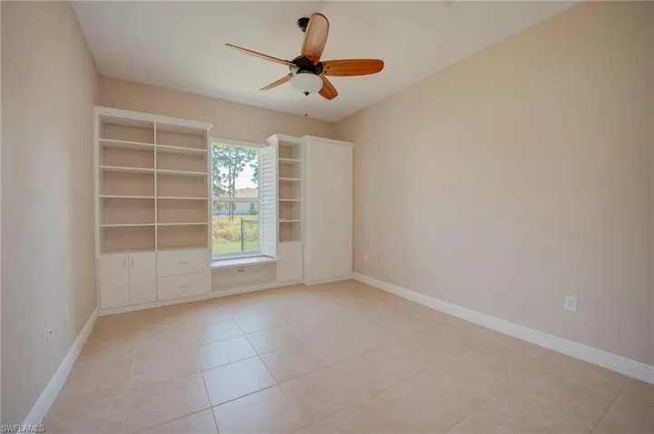 Spare room featuring ceiling fan and light tile patterned floors