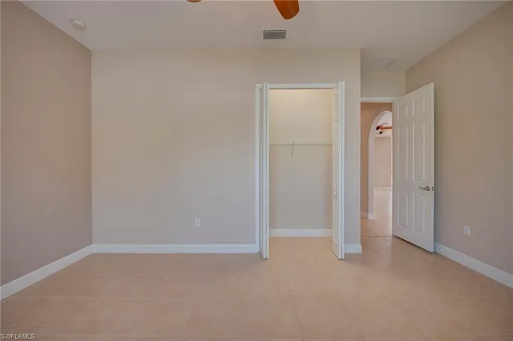 Unfurnished bedroom with a ceiling fan, a closet, and light tile patterned flooring