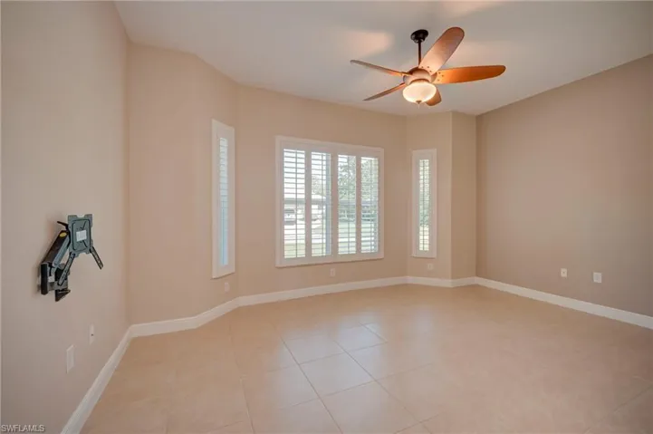 Empty room featuring ceiling fan and light tile patterned flooring