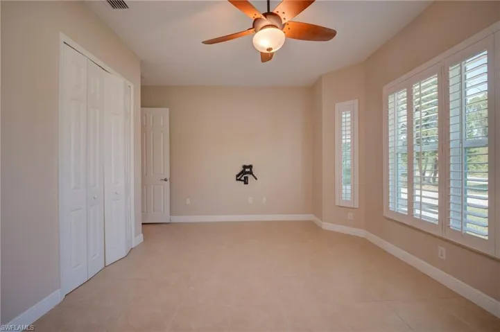Unfurnished bedroom featuring a closet, a ceiling fan, and light tile patterned floors