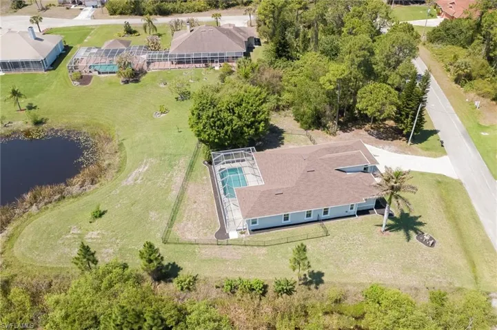Aerial view of property and surrounding area with a nearby body of water