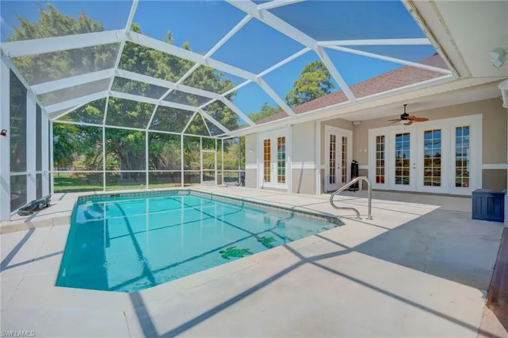 Swimming pool with french doors, a sunroom, a patio, and glass enclosure