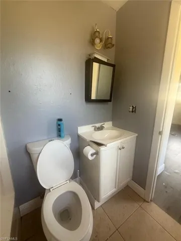 Bathroom featuring a single vanity with an integrated sink, a built-in medicine cabinet, and a two-bulb wall sconce