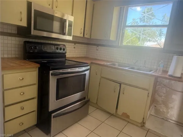 Kitchen featuring a stainless steel range, coordinating stainless steel microwave, and wood-finish countertops