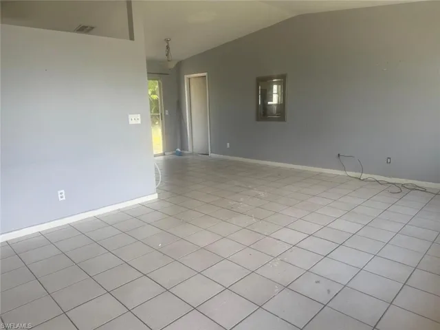 Spacious interior featuring light gray wall tones and ceramic tile flooring throughout
