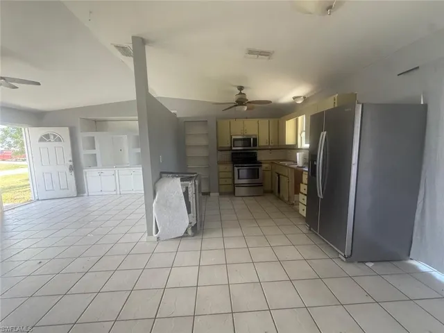 Kitchen area featuring stainless steel appliances including a refrigerator, range, and microwave