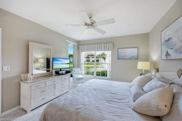 Bedroom with a ceiling fan and light colored carpet
