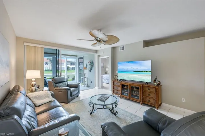 Living area featuring light tile patterned floors and a ceiling fan