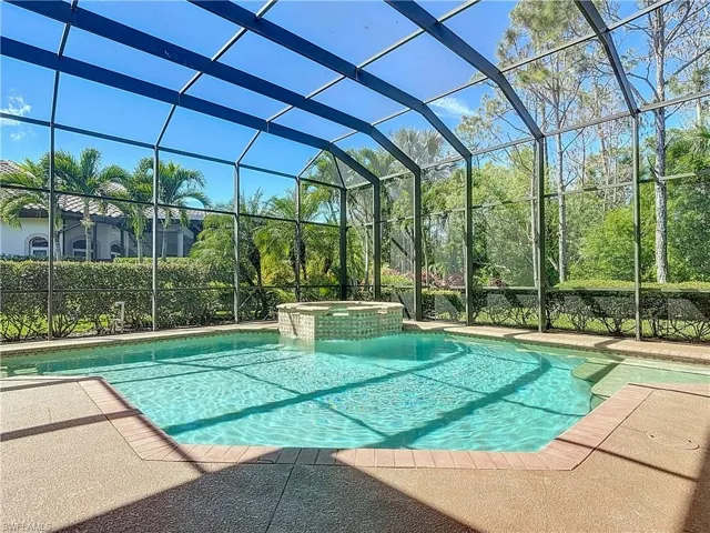 View of swimming pool featuring a patio, a lanai, and a pool with connected hot tub