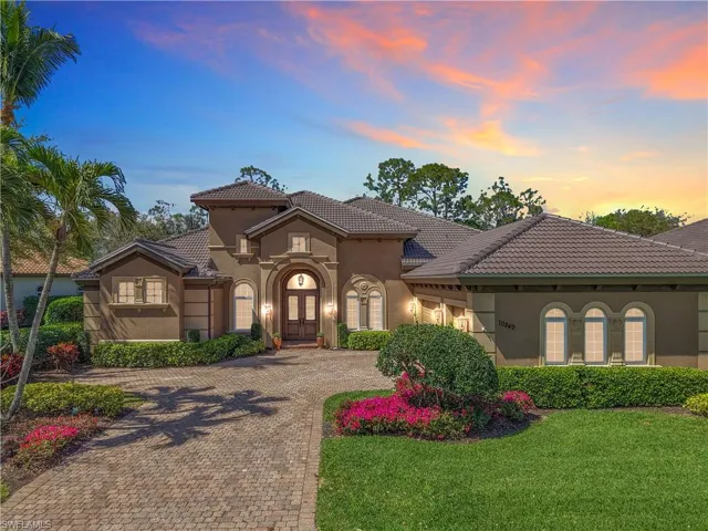 Mediterranean / spanish-style house with a front yard, decorative driveway, a tiled roof, and stucco siding