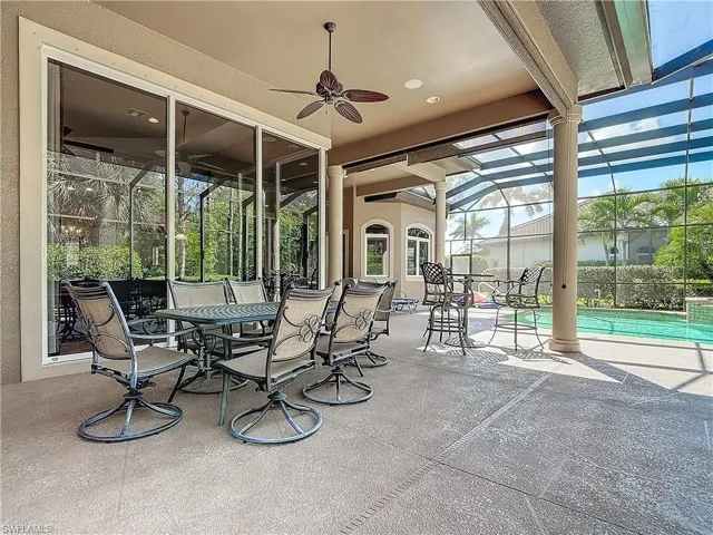 View of patio / terrace featuring ceiling fan, glass enclosure, and a fenced in pool