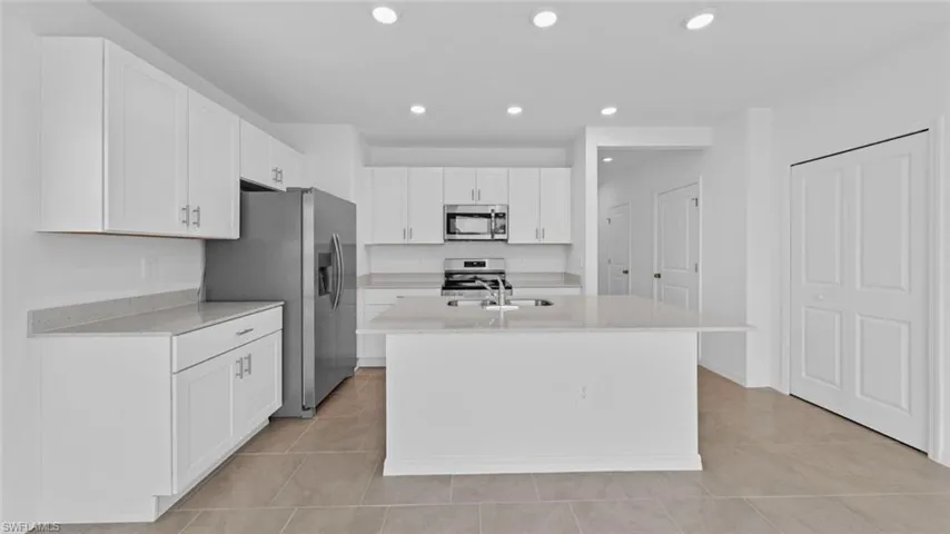 Modern kitchen with stainless steel appliances and center island.