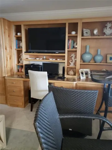 Pre Ian Living room featuring built in desk, built in shelves, and crown molding