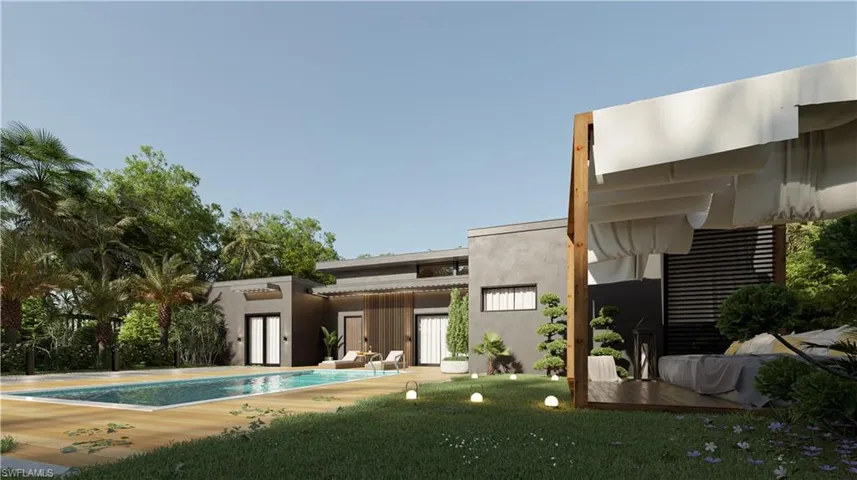 Back of property featuring stucco siding, a patio area, an outdoor pool, and a lawn