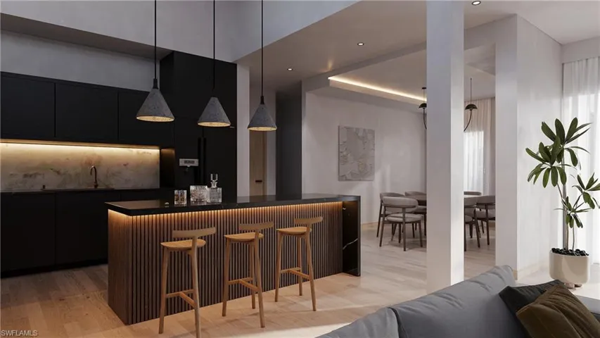 Kitchen featuring a kitchen breakfast bar, dark cabinetry, a center island, and modern cabinets