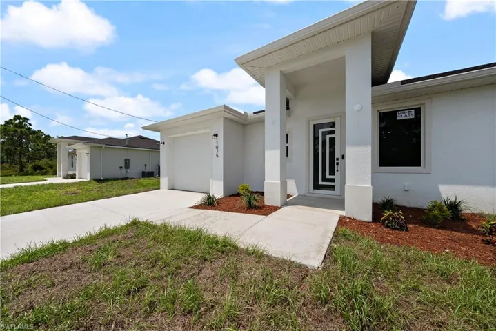 View of front facade with concrete driveway, a garage, and stucco siding
