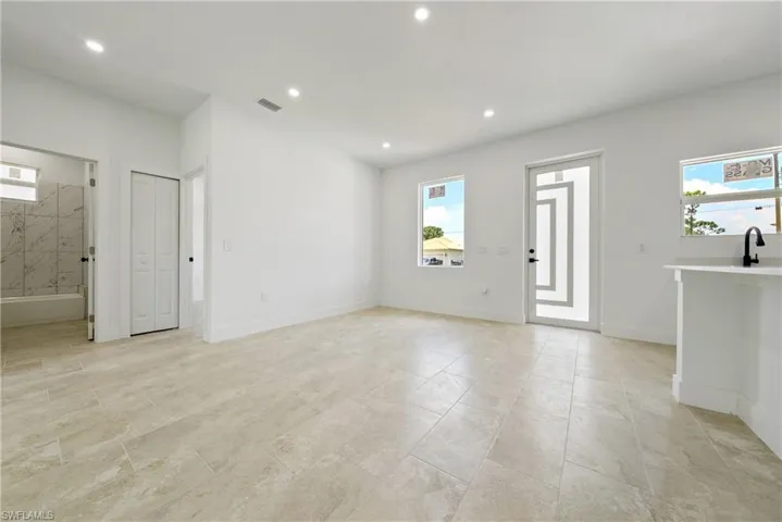 Unfurnished living room featuring recessed lighting and baseboards