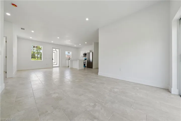 Unfurnished living room with recessed lighting and baseboards