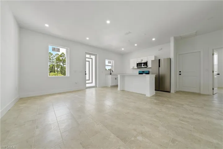 Unfurnished living room with recessed lighting and baseboards