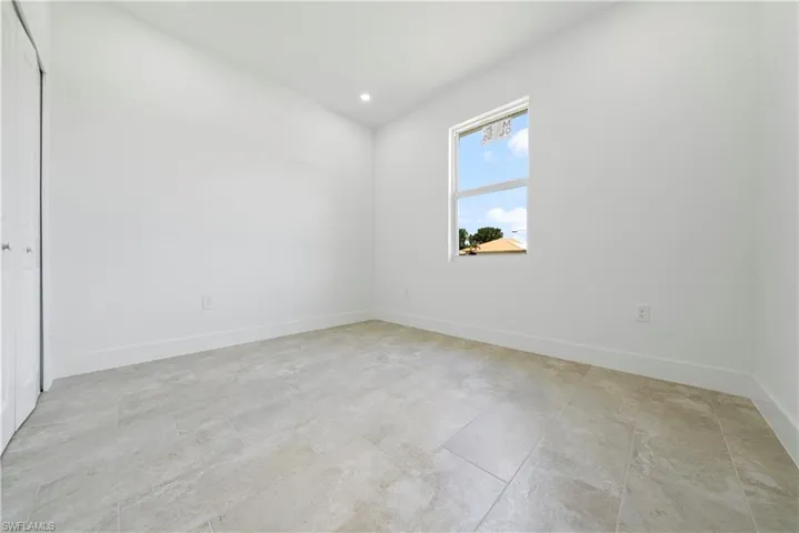 Empty room with baseboards and recessed lighting