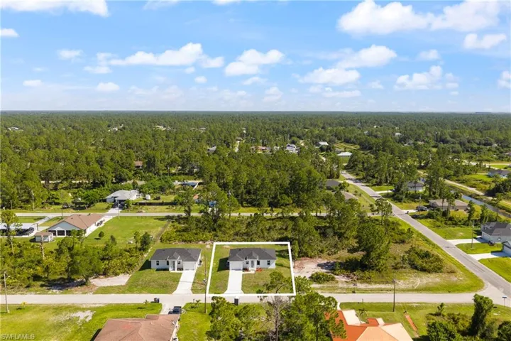 Aerial view of residential area with a heavily wooded area and property boundaries highlighted