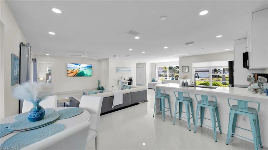 Kitchen featuring a breakfast bar area, light stone counters, a peninsula, open floor plan, and recessed lighting