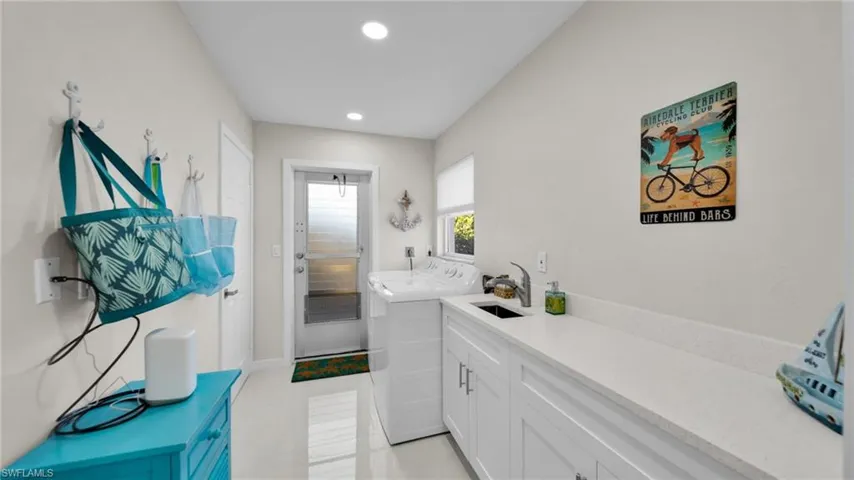 Washroom with recessed lighting, separate washer and dryer, light tile patterned floors, and cabinet space