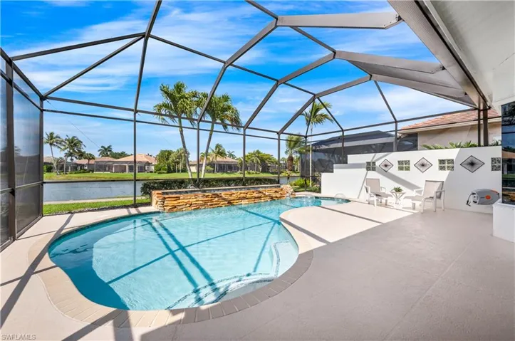 View of pool featuring a patio area, a water view, a lanai, and pool water feature