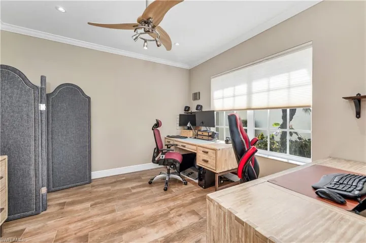Office area featuring ornamental molding, ceiling fan, and light hardwood / wood-style floors