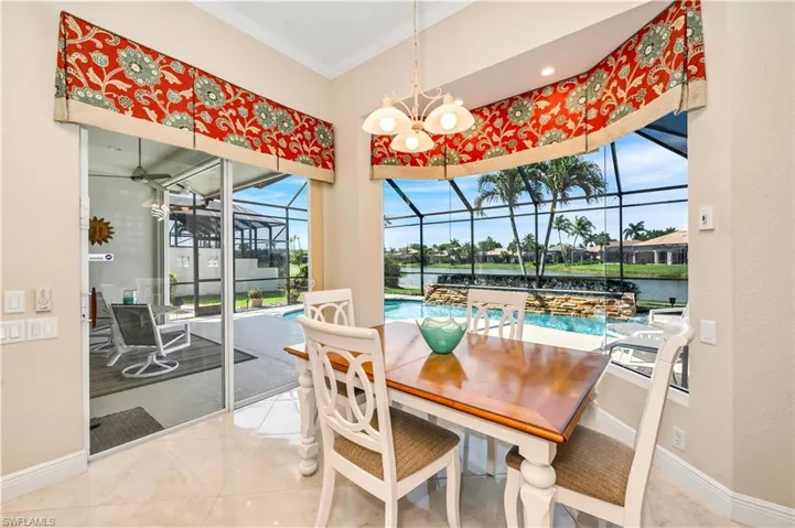 Dining area featuring a wealth of natural light, a chandelier, a water view, and crown molding
