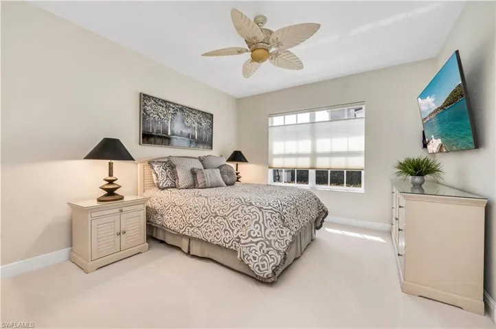 Bedroom with ceiling fan and light carpet