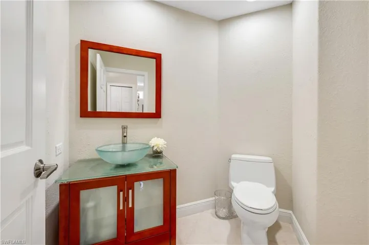 Bathroom with toilet, vanity, and tile patterned floors