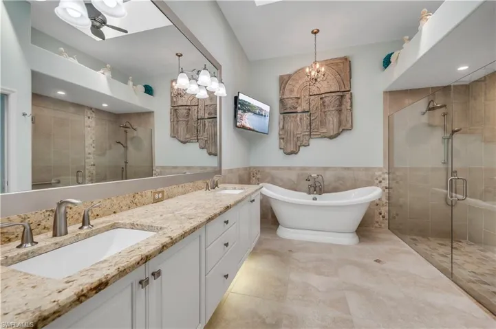 Bathroom featuring tile walls, tile patterned flooring, a chandelier, vanity, and independent shower and bath