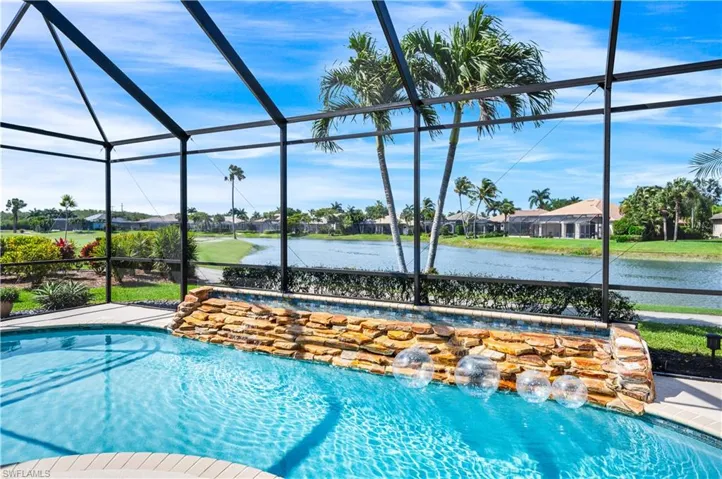 View of swimming pool with a lanai, a water view, and pool water feature