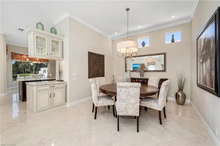 Dining room with sink, an inviting chandelier, and crown molding