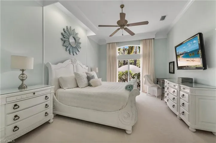 Master Bedroom featuring custom drapes ornamental molding, light carpet, and ceiling fan