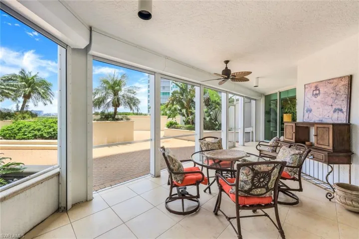 Lanai neutral tile with ceiling fan and hurricane shutters
