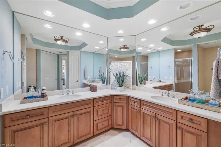 Bathroom with oversized vanity, tile floors, a tray ceiling, and crown molding