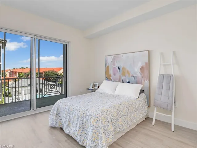Bedroom with access to exterior, wood finished floors, and baseboards
