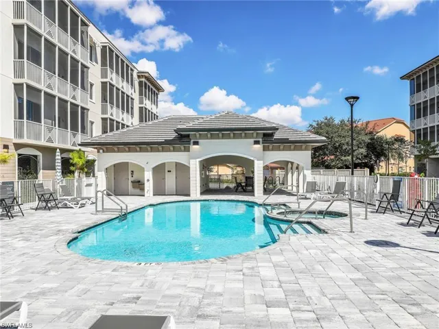 Community pool featuring a patio area and fence
