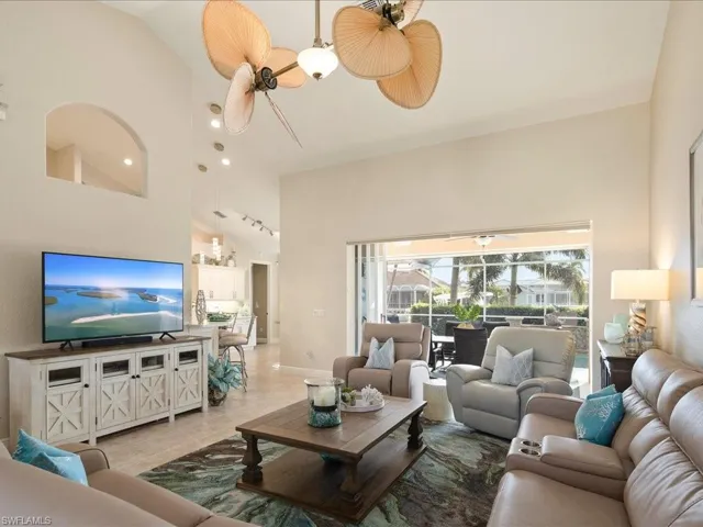 Living room featuring high vaulted ceiling and ceiling fan