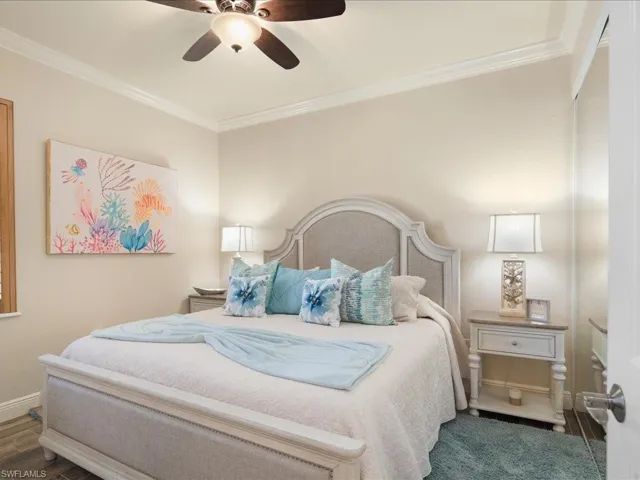 Bedroom featuring ornamental molding, dark wood-type flooring, and ceiling fan