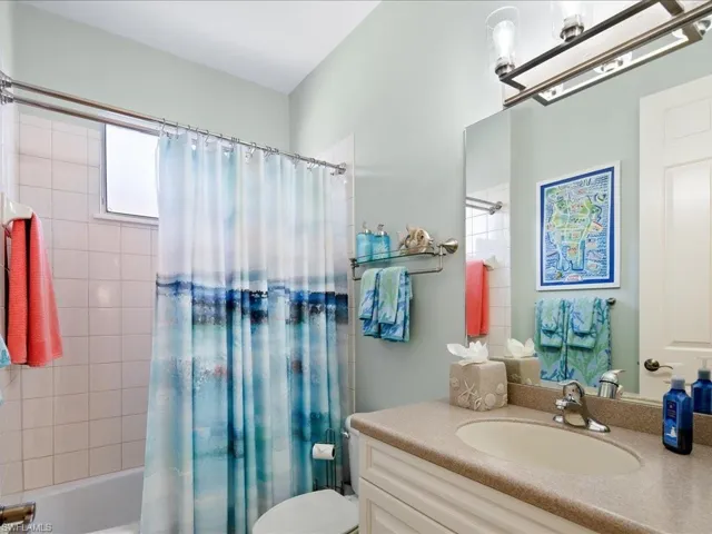 Full bathroom with vanity, toilet, and shower / bath combination with curtain