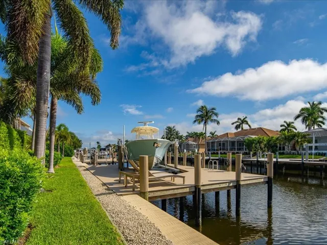 View of dock with a water view and a lawn