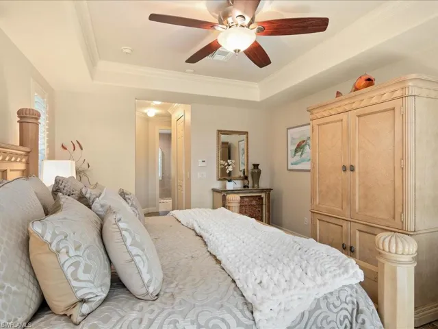 Bedroom with crown molding, ceiling fan, and a raised ceiling